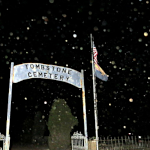 Eerie nighttime view of Tombstone City Cemetery entrance with ghostly atmosphere